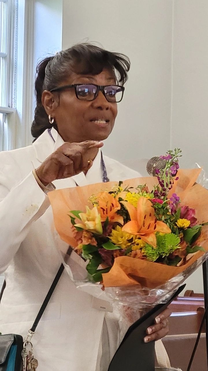 Founder Debbie Ramsey holding a bouquet of flowers